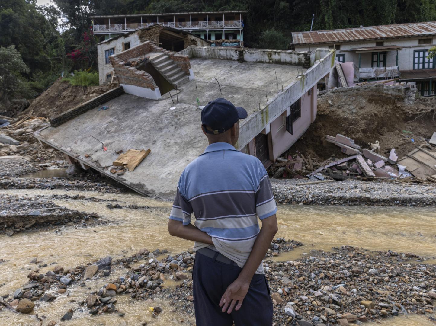 The man in the looking at his damage house due to flood