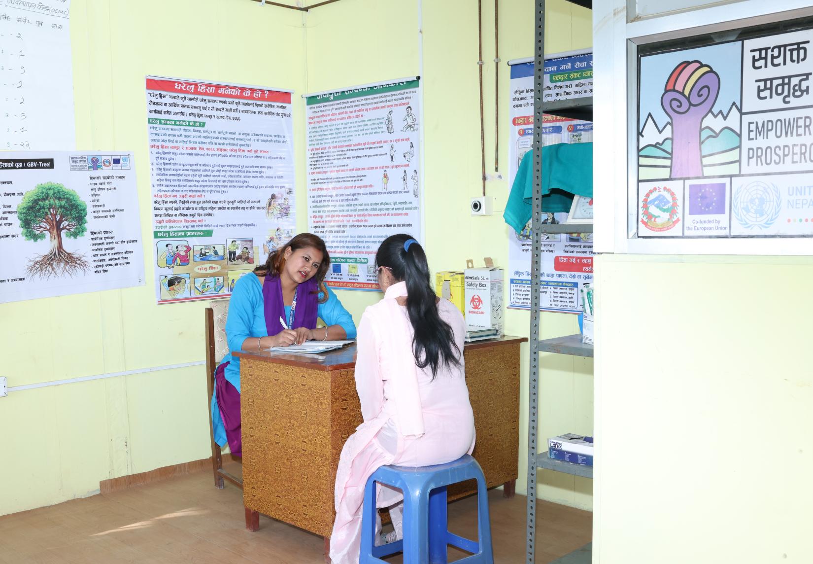 Two women are sitting in a room, with one woman listening attentively to the other.