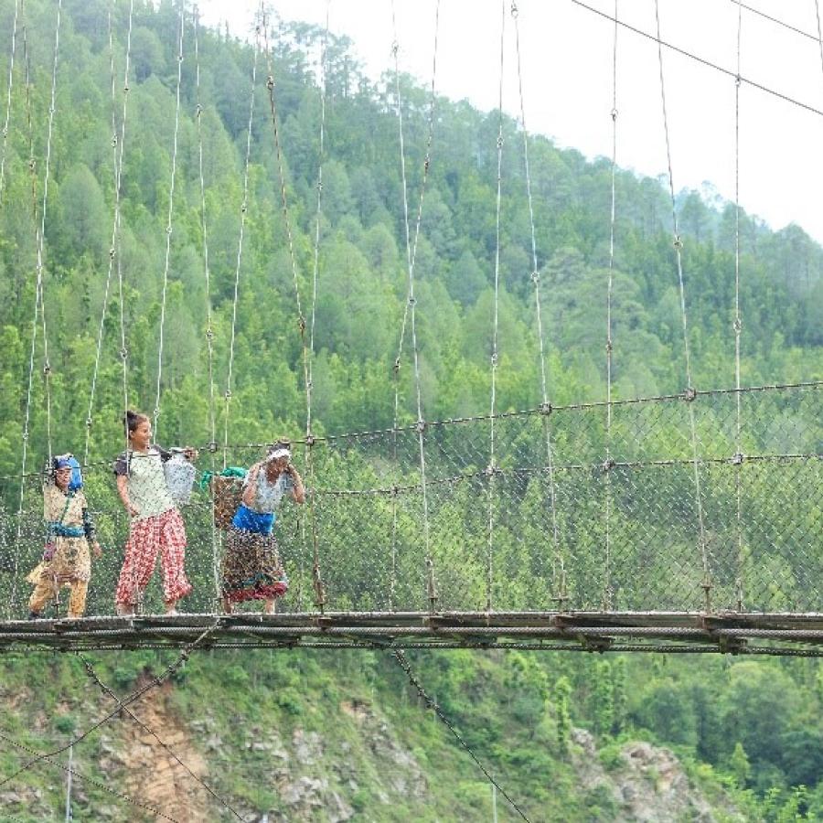 Women carrying water across a bridge over the Bheri River.