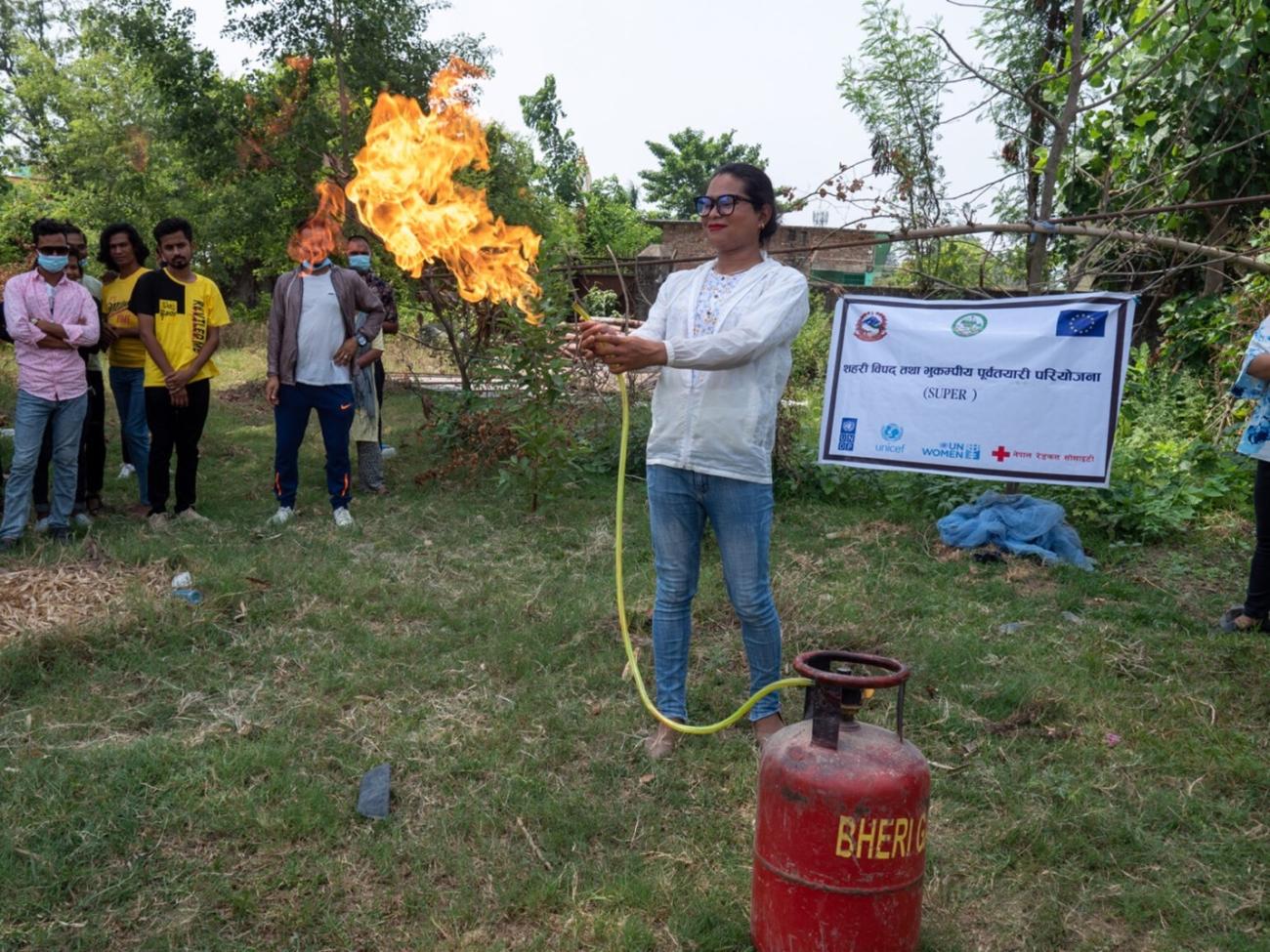 A participant attempts to put out the fire on a gas cylinder, as learned in a Dhangadhi Sub-Metropolitan City organized firefighting training.