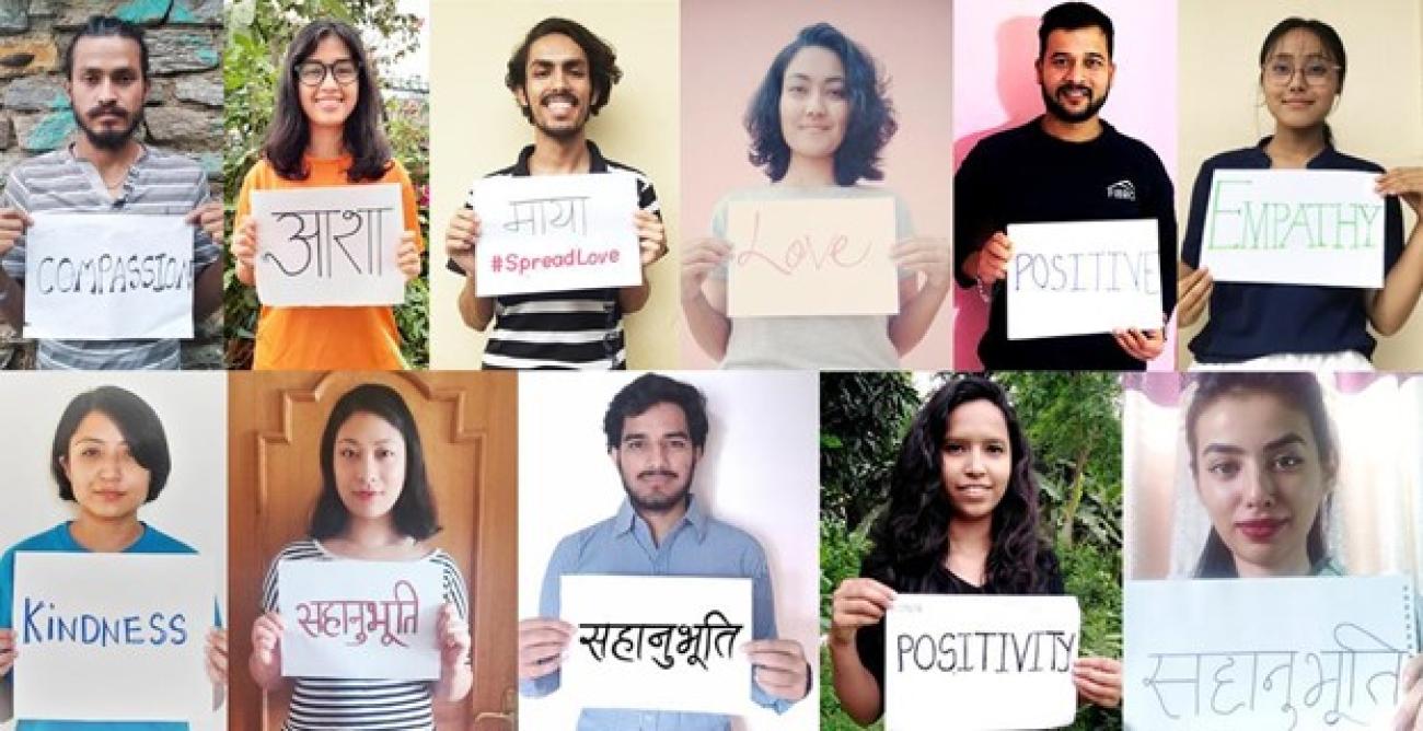 Eleven volunteers look at the front holding a piece of paper that has an adjective each.