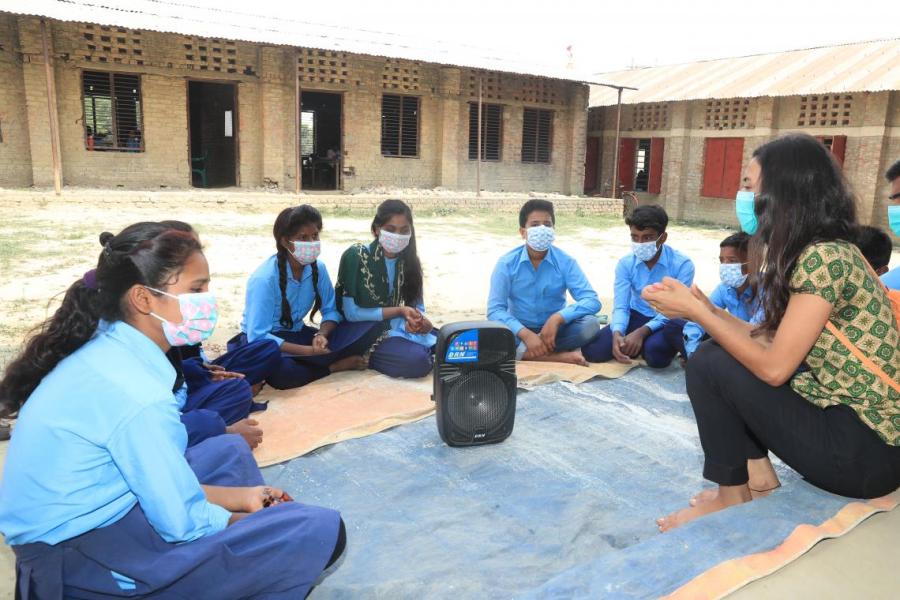 Students of the Shree Nepal Rashtriya Basic School in Parsa District in southern Nepal discuss the latest episode of the Rupantaran radio show under the facilitation of Rupantaran supervisor Palak Thakur (far right)