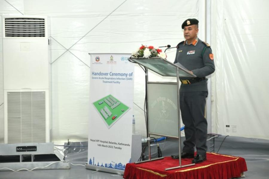 Raju Aryal stands on the podium on stage to give his speech. Chief of Armed Police Force Inspector General, Raju Aryal, providing his remarks at the handover event