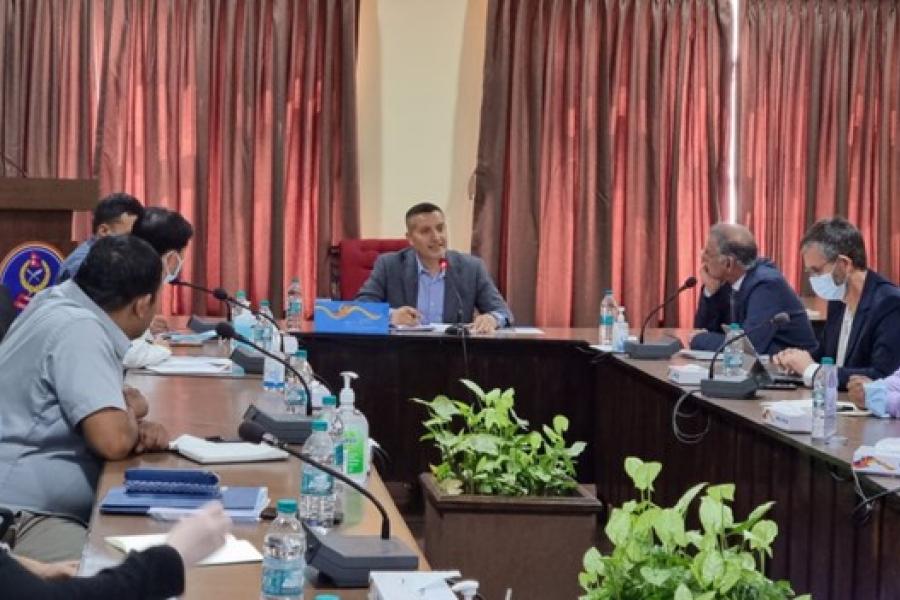 A group of people, around nine of them, discussing with each other at the conference hall.
