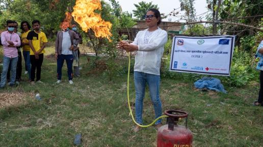 A participant attempts to put out the fire on a gas cylinder, as learned in a Dhangadhi Sub-Metropolitan City organized firefighting training.
