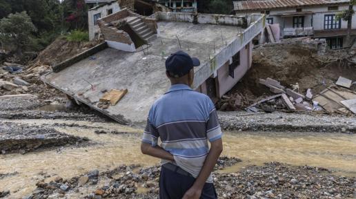 The man in the looking at his damage house due to flood